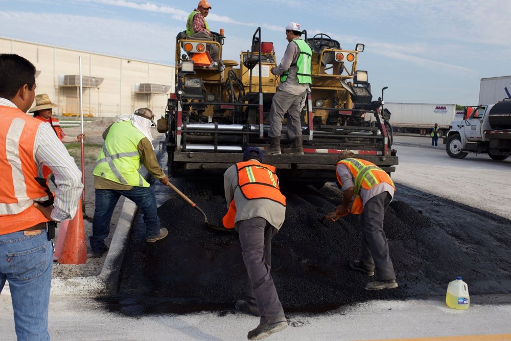 Road crew paving a public roadway with asphalt